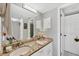Bathroom with granite countertop, dual sinks, and a well-lit vanity mirror at 804 Montrose Dr # 103, Venice, FL 34293