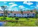 Well-maintained building exterior with lush landscaping and private balconies overlooking the pond at 804 Montrose Dr # 103, Venice, FL 34293