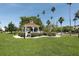 Picturesque gazebo in a park-like setting with palm trees and manicured lawn at 804 Montrose Dr # 103, Venice, FL 34293