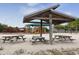 Wooden picnic tables and playground with shade structure at 1172 Kenisco Rd, Venice, FL 34293