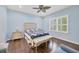 Light blue bedroom with queen-size bed, wooden flooring, and window shutters at 1222 Collier Pl, Venice, FL 34293
