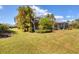 Landscaped backyard with spacious lawn and screened patio at 1222 Collier Pl, Venice, FL 34293