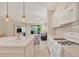 Open kitchen with a view of the living and dining areas, featuring white cabinets and an island at 1222 Collier Pl, Venice, FL 34293