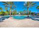 Relaxing community pool area with palm trees and plenty of lounge chairs at 11356 Dancing River Dr, Venice, FL 34292