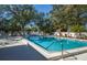 Community pool with lounge chairs and trees at 172 Southampton Pl # 346, Venice, FL 34293