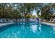 Community pool with lounge chairs and trees at 172 Southampton Pl # 346, Venice, FL 34293