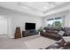 Relaxing living room featuring a leather sofa and large TV, providing ample space for entertainment at 8559 Waldrep St, Port Charlotte, FL 33981