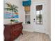 Bright entryway with antique dresser and coastal art at 9888 Bright Water Dr, Englewood, FL 34223