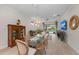 Open dining room with glass-top table, chandelier, and view into the living room at 9888 Bright Water Dr, Englewood, FL 34223