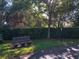 Wooden park bench situated in a lush, shady area at 1704 Triano Cir # 1704, Venice, FL 34292
