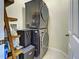 Stackable washer and dryer in well-lit laundry room with shelving at 1704 Triano Cir # 1704, Venice, FL 34292