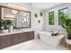 A bright bathroom featuring a soaking tub, a large mirror and a vanity at 1109 Bayshore Rd, Nokomis, FL 34275
