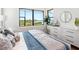 Serene bedroom with water view, featuring sleek white furnishings, stylish decor, and abundant natural light at 1109 Bayshore Rd, Nokomis, FL 34275