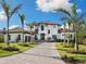 Beautiful two-story home featuring manicured landscaping and a paver driveway lined with palm trees at 1109 Bayshore Rd, Nokomis, FL 34275