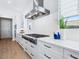 Close-up of the modern kitchen featuring stainless steel appliances, white cabinetry, and quartz countertops at 1109 Bayshore Rd, Nokomis, FL 34275