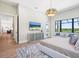 This main bedroom features wood floors, a modern light fixture and an ensuite bathroom at 1109 Bayshore Rd, Nokomis, FL 34275