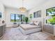 Bright main bedroom featuring a tray ceiling, neutral colors, a large bed, and serene water view at 1109 Bayshore Rd, Nokomis, FL 34275