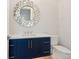 Chic powder room with navy blue vanity, quartz countertop, decorative mirror, and modern fixtures at 1109 Bayshore Rd, Nokomis, FL 34275