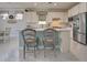 Kitchen island with seating, white cabinets, and stainless steel appliances at 13848 Rinuccio St, Venice, FL 34293