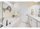 Peaceful bathroom featuring a soaking tub, white cabinetry, and a window at 13848 Rinuccio St, Venice, FL 34293