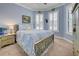 Serene bedroom with light blue walls, a comfortable bed, and plenty of natural light at 13848 Rinuccio St, Venice, FL 34293
