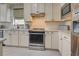 Modern kitchen features stainless steel appliances and diamond pattern backsplash at 13848 Rinuccio St, Venice, FL 34293