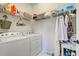 Convenient laundry room with washer, dryer, and ample storage shelving at 13848 Rinuccio St, Venice, FL 34293