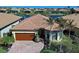 Single-story home with brown garage door and palm trees at 13848 Rinuccio St, Venice, FL 34293