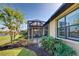 Landscaped backyard with screened patio and partial water view at 13848 Rinuccio St, Venice, FL 34293