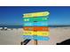 Scenic beach with a signpost showing distances to major cities, clear blue water, and pristine sand at 147 Tampa E Ave # 202, Venice, FL 34285