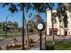Charming street view of the Historic KMI Building featuring a vintage clock and palm trees at 147 Tampa E Ave # 202, Venice, FL 34285