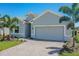 A gray house with a two-car garage and palm trees at 16851 Terrapin Key Dr, Port Charlotte, FL 33953