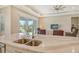 Kitchen island with double sink and quartz countertop overlooking the living room at 19830 Bridgetown Loop, Venice, FL 34293