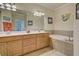 Bathroom with double vanity, soaking tub, and coastal decor offers a relaxing space at 20190 Ragazza Cir # 202, Venice, FL 34293