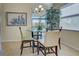 Breakfast nook features modern table, stylish chairs, large bright windows with blind coverings and a tree at 20190 Ragazza Cir # 202, Venice, FL 34293