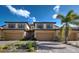 Beautiful townhome exterior featuring a two-car garage, brick driveway, desert landscaping, and neutral color palette at 20190 Ragazza Cir # 202, Venice, FL 34293