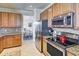 Well-equipped kitchen with stainless steel appliances, granite countertops, and wood cabinetry at 20190 Ragazza Cir # 202, Venice, FL 34293