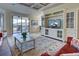 Bright living room featuring a large entertainment center, access to patio, and comfortable seating at 20190 Ragazza Cir # 202, Venice, FL 34293
