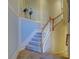 Carpeted staircase with white wood trim, railing, and tiled floor, featuring elegant wall decor at 20190 Ragazza Cir # 202, Venice, FL 34293