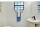 Small bathroom with a toilet and pedestal sink at 20391 Lagente Cir, Venice, FL 34293