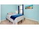 Bedroom with blue walls, carpeted floor, and striped bedding at 20391 Lagente Cir, Venice, FL 34293
