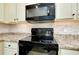 Black Whirlpool range and microwave in a modern kitchen at 20391 Lagente Cir, Venice, FL 34293