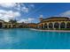 Large community pool with a clubhouse and palm trees at 20391 Lagente Cir, Venice, FL 34293