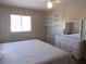 Bright bedroom featuring wood-paneled walls, a double bed, and a classic white dresser with a matching mirror at 359 Longwood Dr, Venice, FL 34285