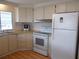 Functional kitchen with white appliances, wooden cabinets, and a window providing natural light at 359 Longwood Dr, Venice, FL 34285