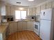 Bright kitchen featuring ample white cabinetry, laminate countertops, and modern white appliances at 359 Longwood Dr, Venice, FL 34285