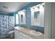 Bathroom with double sinks, light blue walls, and shower/tub combo at 428 Boxwood Dr, Venice, FL 34285