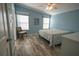 Main bedroom with blue walls, ceiling fan, and access to bathroom at 428 Boxwood Dr, Venice, FL 34285