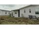This home has a lawn, a concrete pad, a covered patio and an air conditioning unit at 6234 Parakeet Rd, Englewood, FL 34224