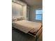 Cozy bedroom with a stylish murphy bed, built-in shelves, and plenty of natural light at 6234 Parakeet Rd, Englewood, FL 34224
